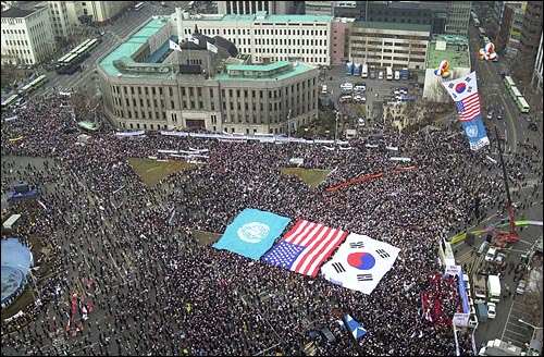 참가자의 머리위를 덮은 대형 태극기와 성조기, 유엔기. 